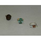 A smoky quartz set dress ring together with a blue stone set dress ring and a three stone ring with