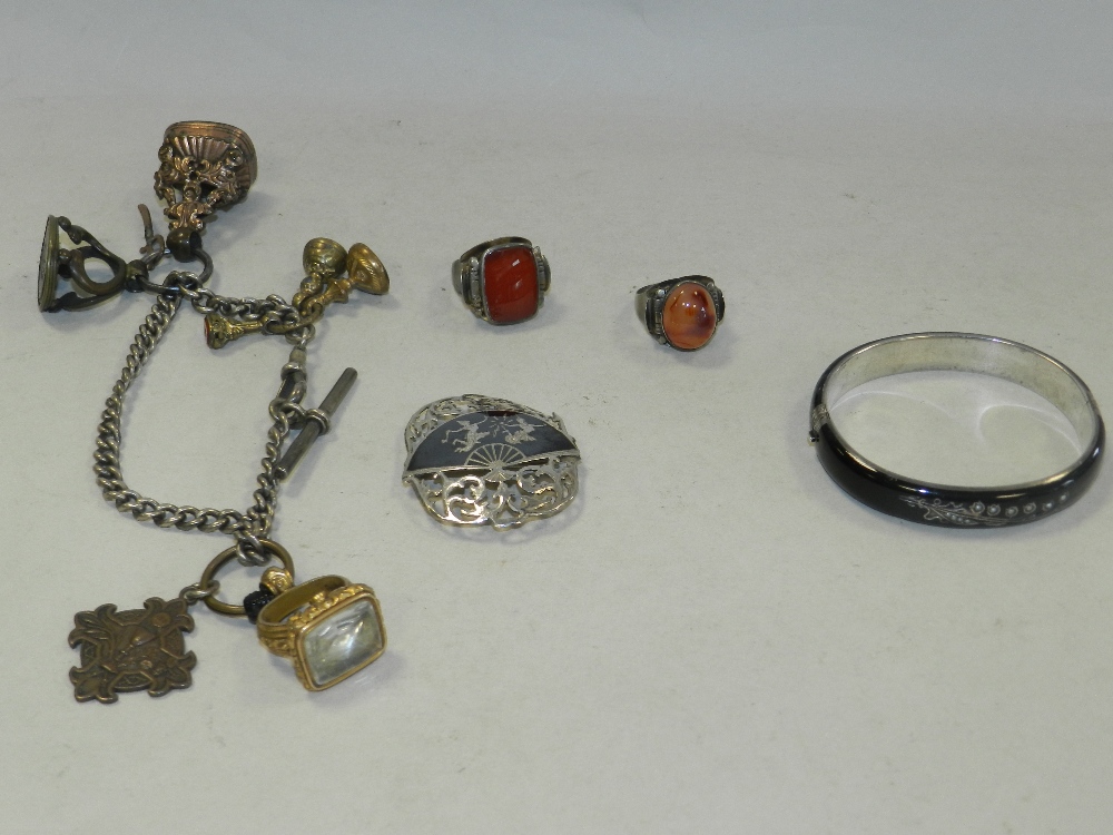 A collection of hard stone set fobs, a white metal and niello work brooch,