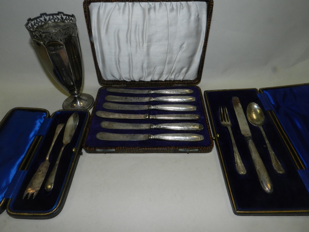 A cased three piece silver christening set comprising knife, fork and spoon, a silver vase,
