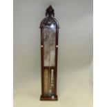 An Admiral Fitzroys barometer with exposed mercury level in a walnut case with leaf moulded arched
