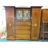 An Edwardian mahogany inlaid wardrobe with two hanging cupboard either side of four long drawers