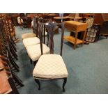 A set of four Edwardian mahogany dining chairs with overstuffed upholstered seats