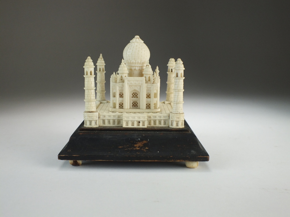 An Indian ivory model of the Taj Mahal, early 20th Century, set on a shaped wood base, 10cm high.