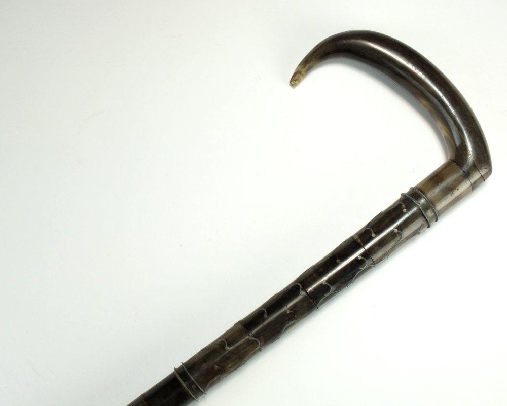 A mixed horn inlaid walking stick, probably Indian, the L-shaped head above a tapering stick,