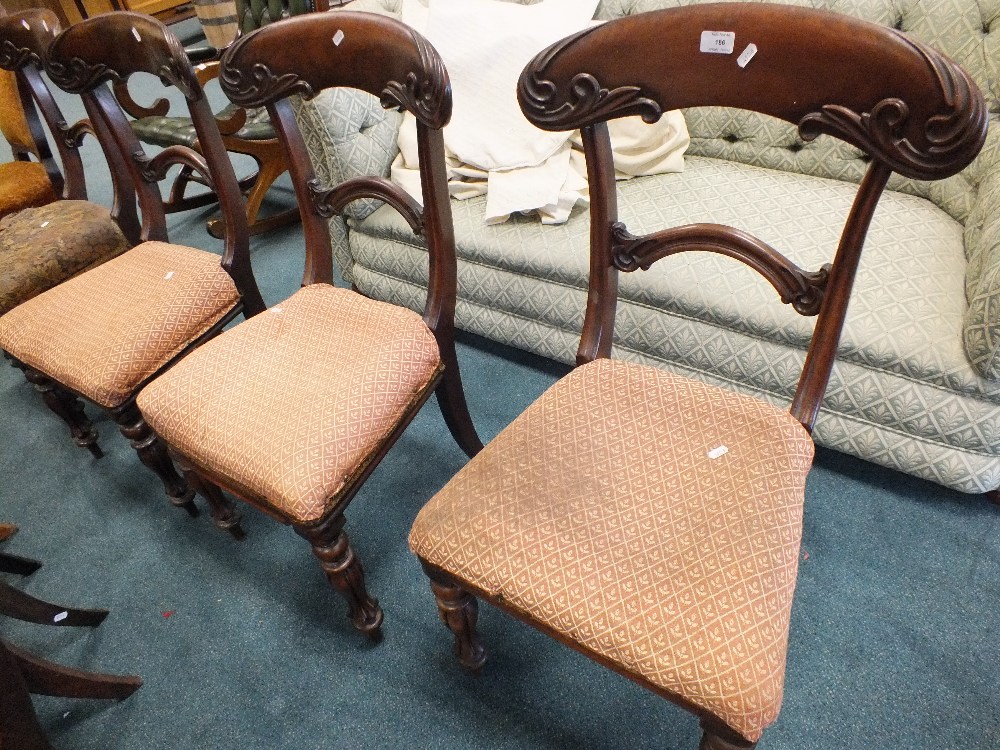 A set of four late Victorian carved mahogany dining chairs with overstuffed seats and a late