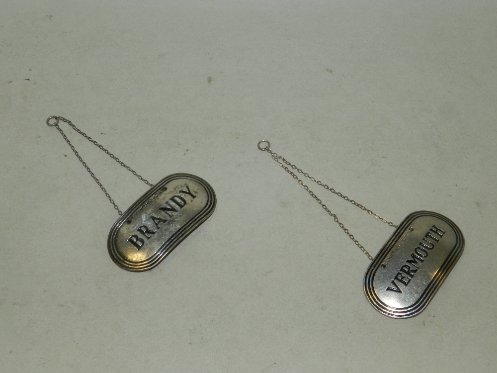 Two silver decanter labels hallmarked Birmingham, 'Brandy' and 'Vermouth'.