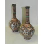 A pair of Japanese cloisonne vases of bottle form and decorated with panels of exotic birds and