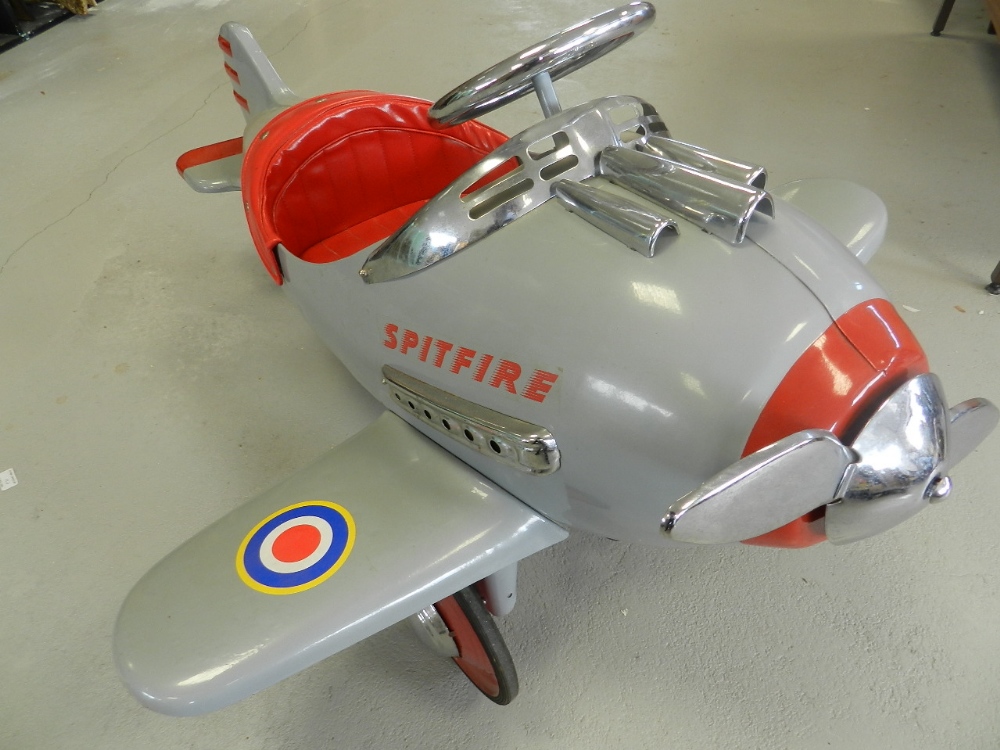 A pedal car in the form of a Spitfire aircraft,