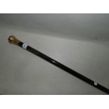 A yellow metal mounted ebonised walking cane.