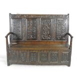 An 18th century and later oak box seat settle the carved top rail bares the date 1700 over four