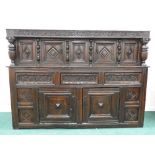 A Charles II and later oak court/press cupboard of large proportions the scrolling and leaf carved