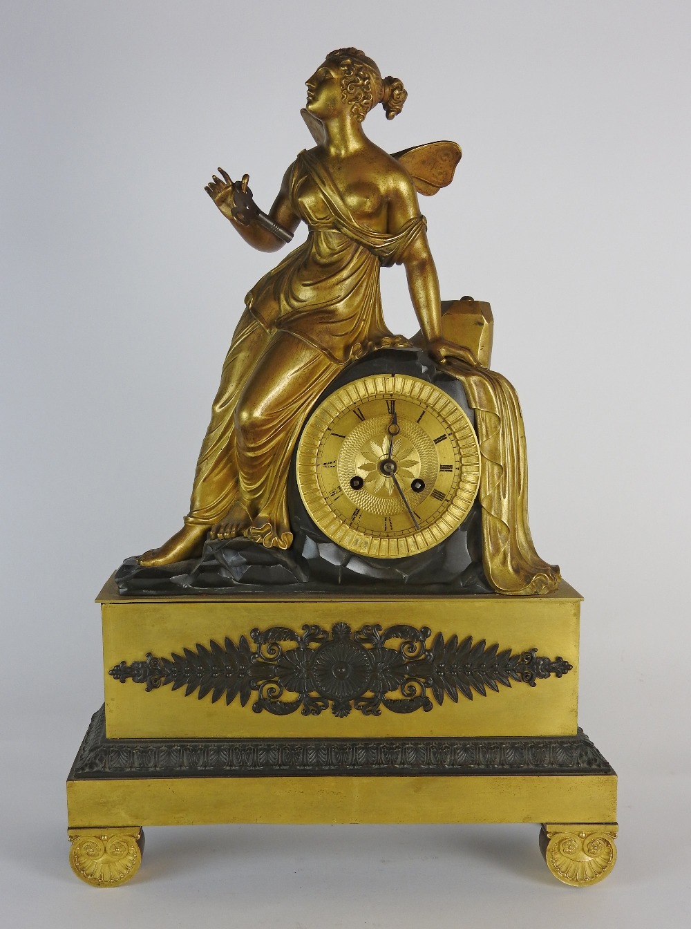 An early 19th century Empire style Ormolu figural mantle clock the 4 inch dial with ring of Roman