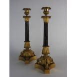 A pair of Charles X gilt metal candlesticks each with urn shaped nozzle over a basket capital and