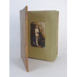 A 20th century leather covered photo album opening to reveal 13 signed publicity cards for early