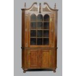 A 19th century American cherrywood full height floor standing corner cabinet in the Chippendale