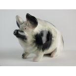 A small black pig by Wemyss, circa 1900, seated in black and white colouring, impressed Wemyss mark,