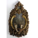 An 18th century and later Rococo style girandole the shaped mirror plate within a C scroll and