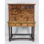 An early 18th century and later walnut chest on stand the quarter veneered top with feather banded