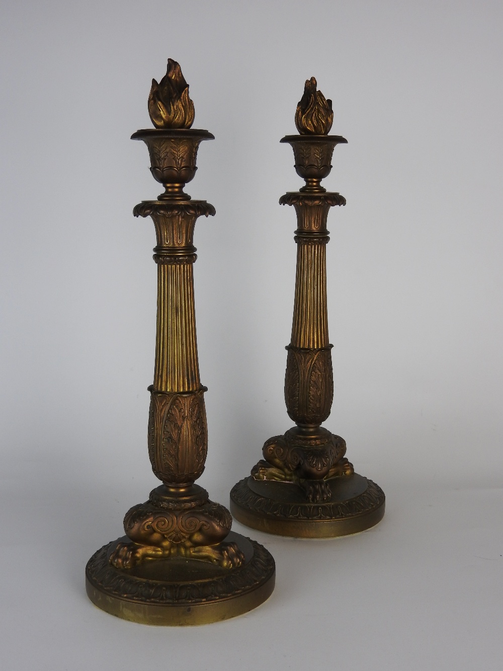 A pair of Charles X ormolu candlesticks each on a circular base with lion monopodium,