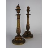 A pair of Charles X ormolu candlesticks each on a circular base with lion monopodium,