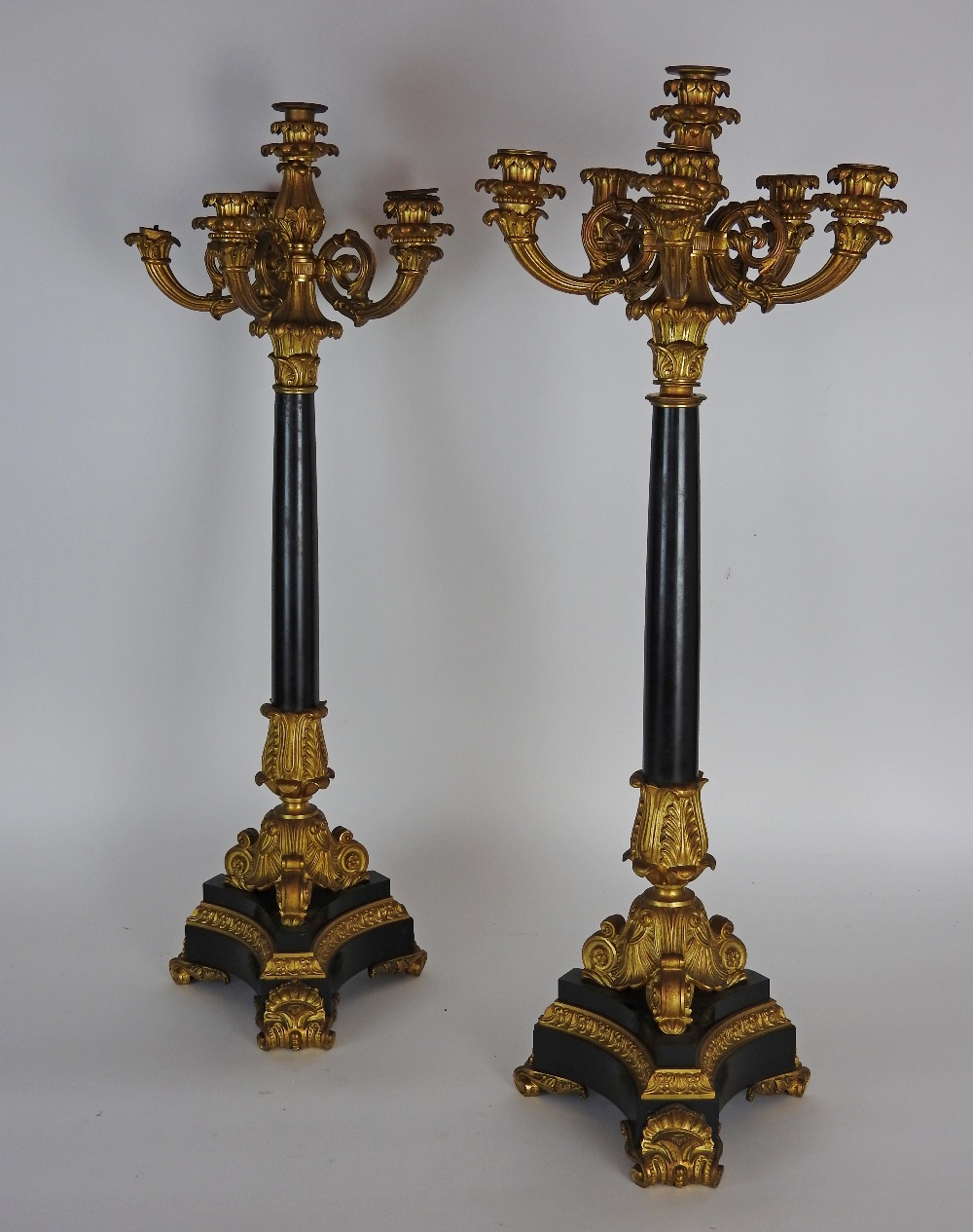 A pair of Charles X ormolu mounted black marble six light candelabra each on triangular shaped