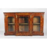 A mid Victorian figured walnut veneered breakfront glazed low bookcase with gilt metal mounts.