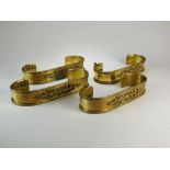 Four 20th century gilt brass curtain tie backs in the classical style with pierced anthemion