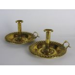 a pair of 19th century pressed brass and push up chamber sticks with short column,