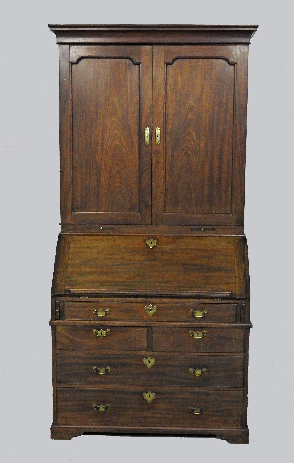 A George II mahogany bureau cabinet, the upper section with two arched panel doors,