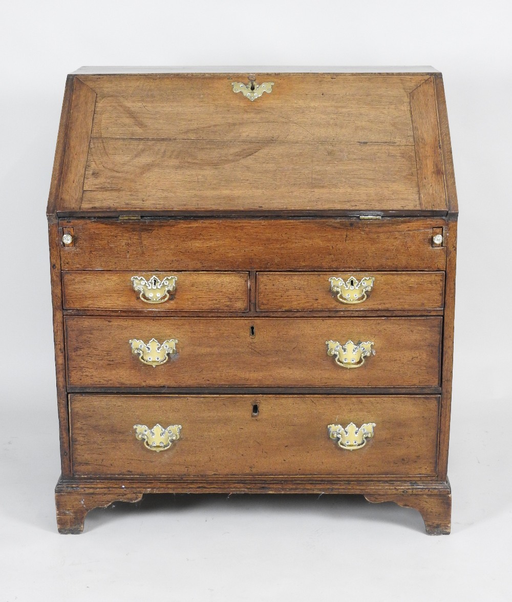 A mid 18th century oak fall front bureau the fall revealing a well fitted interior of short drawers