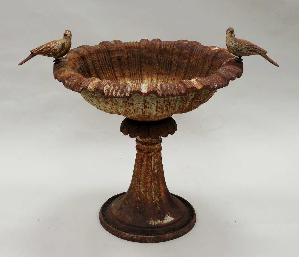 An early 20th century cast-iron birdbath of shallow form with two cast bird mounts on a flared