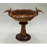 An early 20th century cast-iron birdbath of shallow form with two cast bird mounts on a flared