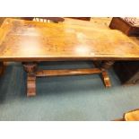 A 17th century style two plank refectory table with cleated ends on heavy end baluster supports.