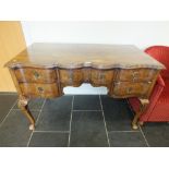 A late Victorian mahogany cross banded serpentine front dressing table in the Dutch style with a