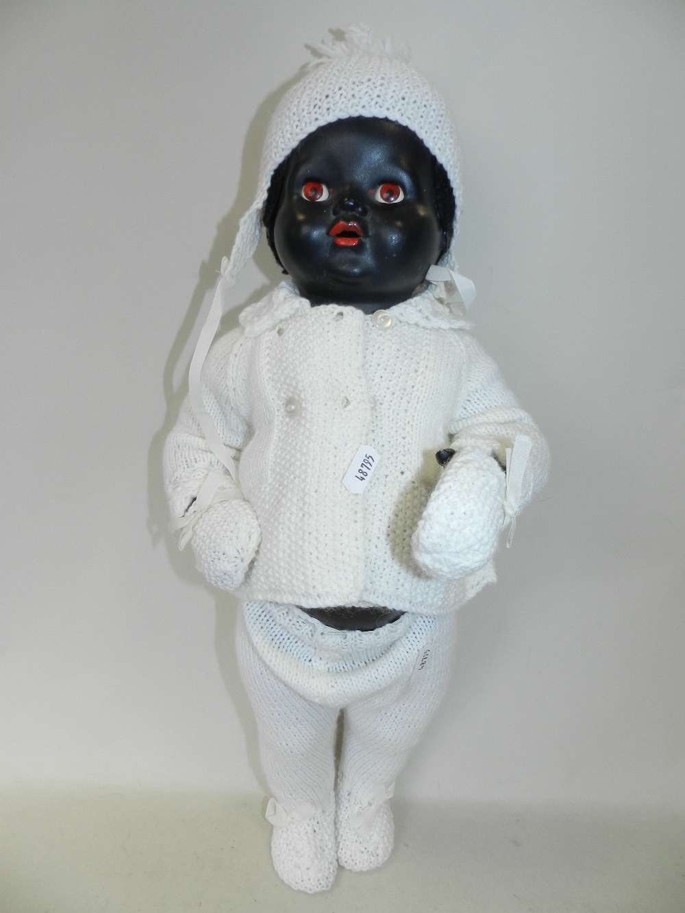 A black baby doll with jointed arms and legs and sleeping brown eyes