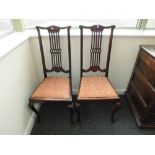 A set of four Edwardian mahogany dining chairs with drop in seat cushions and open work splats.