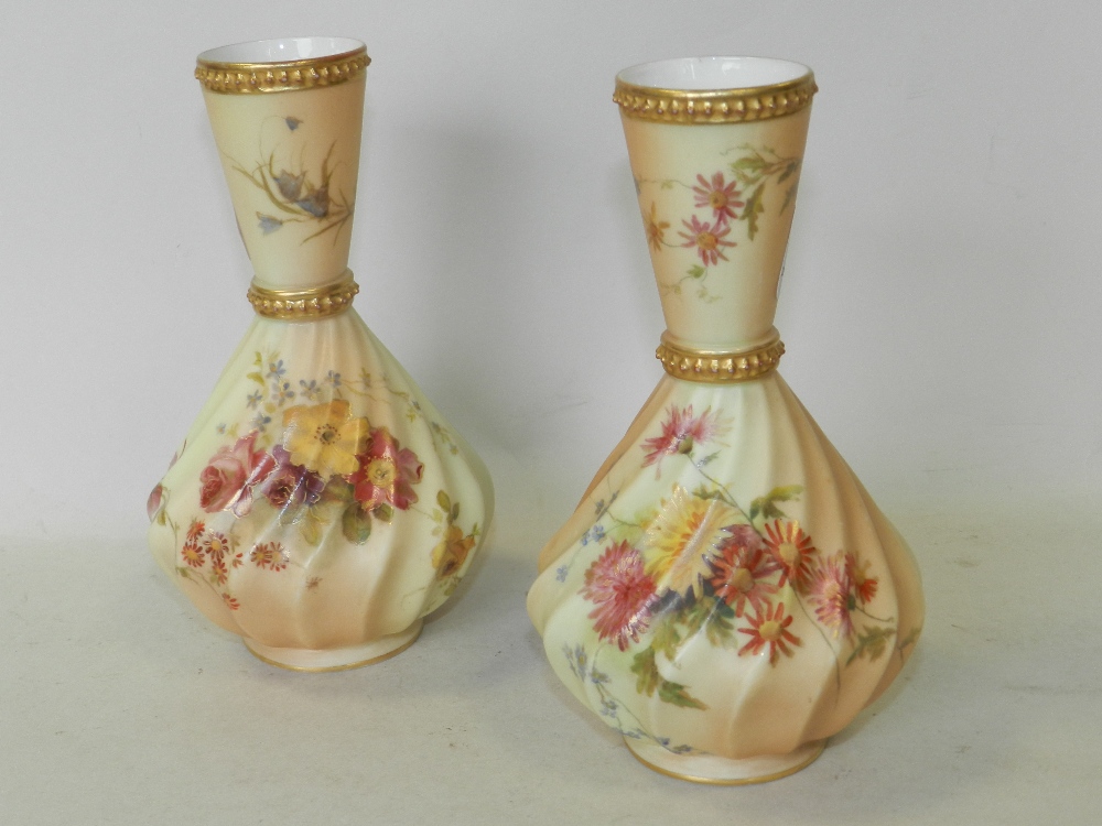 A pair of Royal Worcester blush ivory vases decorated with flowers,