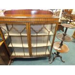 An early to mid 20th century bow front glazed display cabinet raised on ball and claw feet,