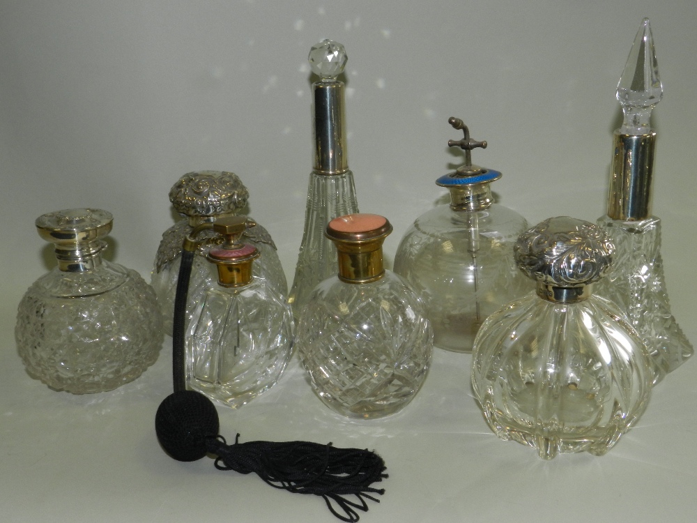 A collection of various silver brass and enamel mounted glass dressing table jars to include