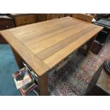 A modern oak plank top rectangular dining table on square legs and draw leaf ends