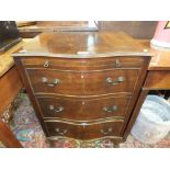 A reproduction serpentine front mahogany chest of three drawers with brushing slide.