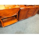 An elm finish low sideboard with three drawers flanked by cupboard doors in Ercol style,