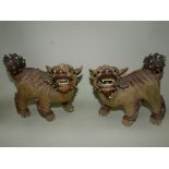 A pair of Chinese brown stoneware or Yixing pottery figures of lion dogs