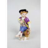 A Meissen porcelain figure of a seated child, 20th century, polychrome decorated,