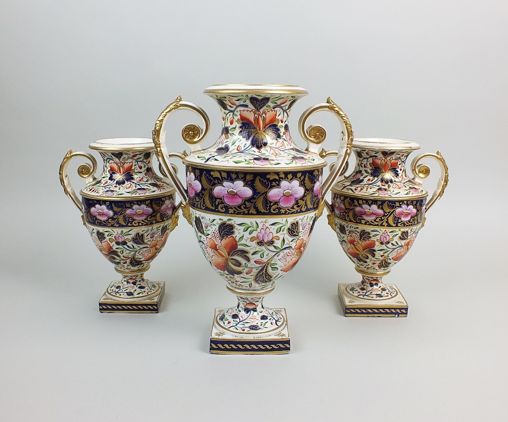 A garniture of three Derby porcelain vases, early 19th century, each of two handled urn form,