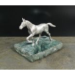 A silver plated model of a horse, naturalistically modelled and mounted to green marble base,