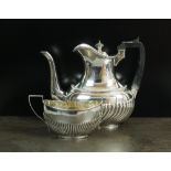 A Goldsmiths and Silversmiths silver coffee pot, London 1910, with embossed decoration the body,