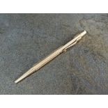 A 9ct gold retractable pencil, E Baker & Son, Birmingham, of hexagonal engine turned form,