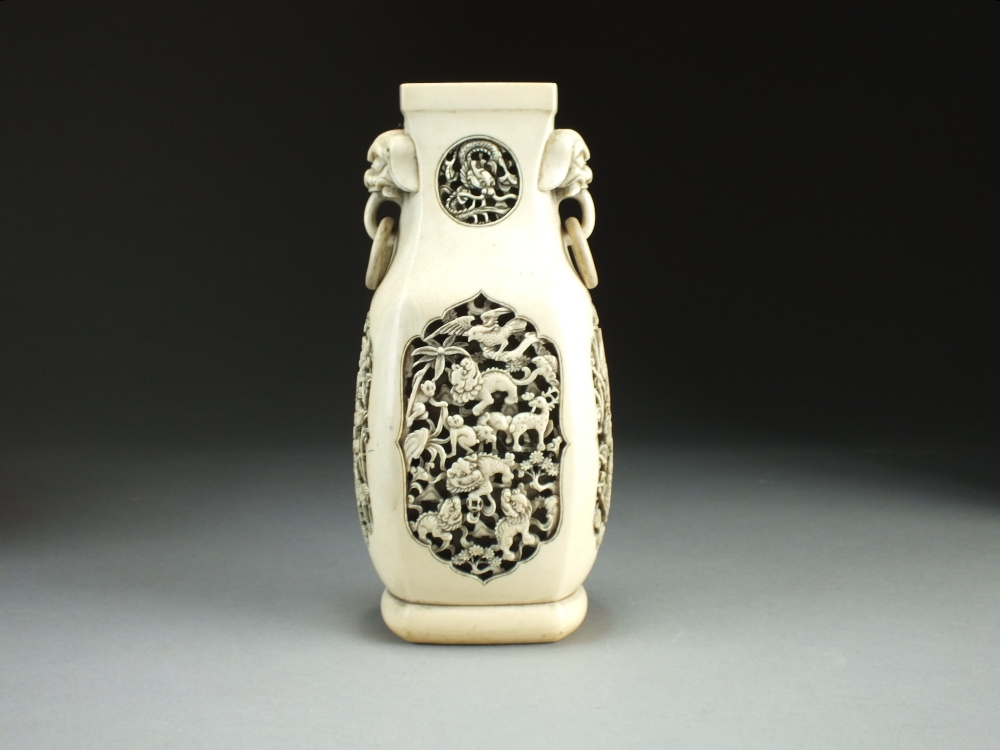 A Chinese carved ivory vase, 19th Century, of rounded square section with lion dog and ring handles,