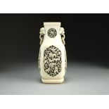 A Chinese carved ivory vase, 19th Century, of rounded square section with lion dog and ring handles,